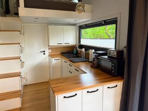a kitchen with white cabinets and a window at Tiny House Hameln in Salzhemmendorf