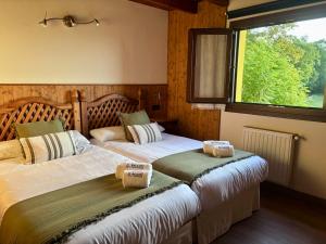 two beds in a room with a window at El Balcón Del Profesor in Cereceda