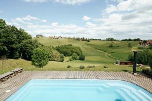 an outdoor swimming pool with a view of a field at ILLYRHof in Gamlitz
