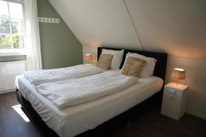 a bedroom with a bed with white sheets and pillows at De Brittenburg 4-persoons, finse sauna, hottub, sunshower, grote zonnige omheinde tuin, wifi en huisdier vriendelijk in Lievelde +75 photos