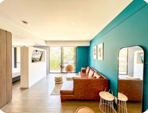 a living room with a brown couch and a blue wall at Distrito Prime 1-302 in Bogotá