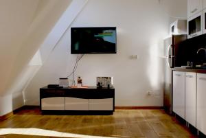 a living room with a tv on a white wall at Apartament Słoneczny Koscielisko in Kościelisko