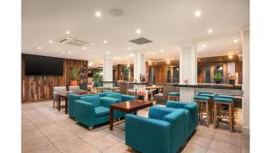 a restaurant with blue chairs and a bar at Holiday Inn Newcastle-Jesmond by IHG in Newcastle upon Tyne