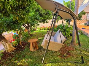 a swing in the grass under an umbrella at Villa Meminaj in Vlorë +69 photos