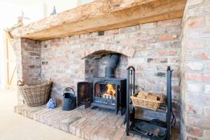 a brick fireplace with a fire in it at Deighton Lodge in York