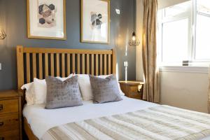 a bedroom with a bed with white sheets and pillows at Deighton Lodge in York