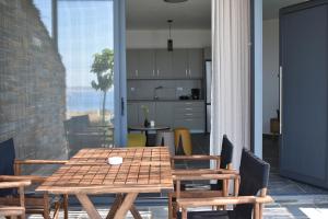 a wooden table and chairs in a room with a kitchen at Μαυρόλιθος in Karistos