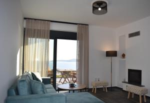 a living room with a blue couch and a large window at Μαυρόλιθος in Karistos