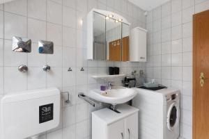 a bathroom with a sink and a washing machine at Fewo Krick in Bad Soden-Salmünster +20 photos