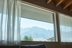 a window with a view of a mountain at SUISUI Hakushu Hotel in Shirasu