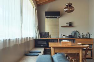 a living room with a table and a dining room at SUISUI Hakushu Hotel in Shirasu