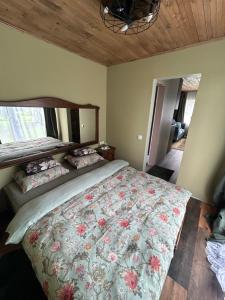a bedroom with a large bed with a floral bedspread at Annsmuiža in Salacgrīva