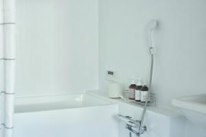 a white bathroom with a sink and a shower at SUISUI Hakushu Hotel in Shirasu +44 photos
