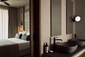 a hotel room with a bed and two sinks at Zelia Halkidiki, part of Destination by Hyatt - Adults Only in Nea Potidaea +87 photos