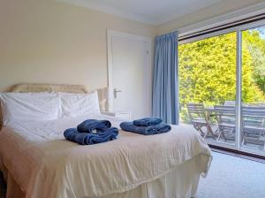 a bedroom with a bed with blue towels on it at Still Waters, Emsworth in Emsworth