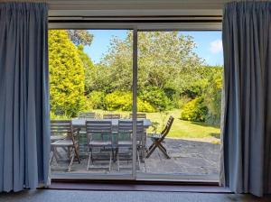 a patio with a table and chairs outside a window at Still Waters, Emsworth in Emsworth