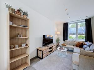 a living room with a couch and a tv at Stellaross - Koksijde in Koksijde