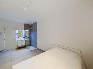 a bedroom with a white bed and a bathroom at Stellaross - Koksijde in Koksijde