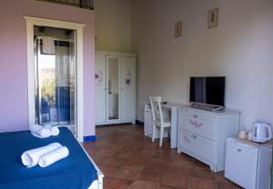 a room with a bed and a desk and a television at Al Palmento Country Hotel in Syracuse