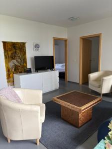 a living room with white furniture and a tv at Bifröst Apartments in Bifrost