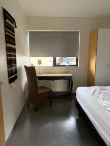 a bedroom with a desk and a chair and a bed at Bifröst Apartments in Bifrost
