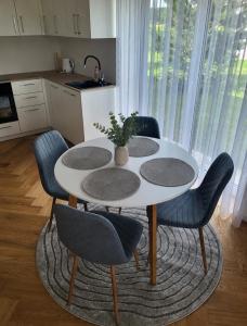 a kitchen with a table with four chairs and a table at Wake&wave in Užpelkiai