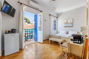 a living room with a bed and a table and chairs at Adonis Rooms in Skopelos Town