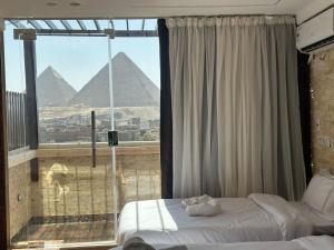 a bedroom with a view of the pyramids at Vida Pyramids Inn in Cairo