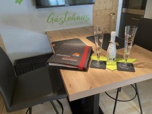 a table with a book and two glasses on it at Fewo TG in Schliersee