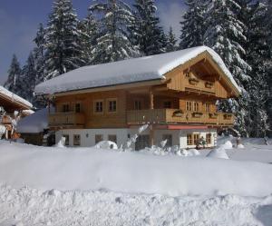 a log cabin in the snow with snow covered at Fewo TG in Schliersee