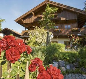 a house with red flowers in front of it at Fewo TG in Schliersee