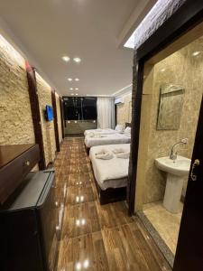 a hotel room with three beds and a sink at Vida Pyramids Inn in Cairo +39 photos