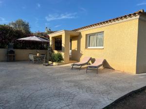 a patio with two chairs and an umbrella next to a building at CASA Petra Rosa in Peri