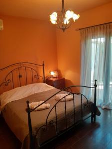 a bedroom with a bed and a window and a chandelier at Mulberry Tree in Agia Anna