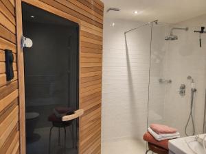 a bathroom with a shower and a glass door at Logement Welgelegen - Charming private stay with sauna near Nijmegen in Millingen aan de Rijn