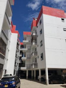 a building with a car parked in front of it at SPACIOUS VIP 1 BEDROOM with ROOFTOP SWIMMING POOL AVAILABLE in Mtwapa