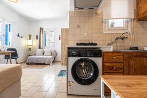 a kitchen with a washing machine in a kitchen at Tzivaeriparos studio in Piso Livadi