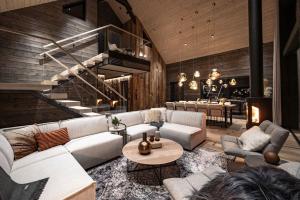 a living room with a couch and a staircase at AURA Arctic Chalets - Grand Panoramic & Grand Hideaway in Saariselka