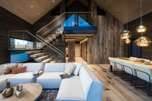 a living room with a white couch and a staircase at AURA Arctic Chalets - Grand Panoramic & Grand Hideaway in Saariselka