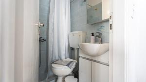 a small bathroom with a toilet and a sink at Tzivaeriparos studio in Piso Livadi +38 photos