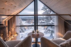 a room with a large window with a winter view at AURA Arctic Chalets - Grand Panoramic & Grand Hideaway in Saariselka