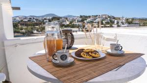 a table with food and drinks on a balcony at Tzivaeriparos studio in Piso Livadi