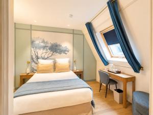 a bedroom with a bed and a desk and a window at Hôtel Le Cardinal in Paris +97 photos