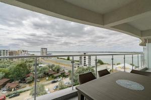 a balcony with a table and a view of a city at Black Sea Booking - Helsinki in Năvodari