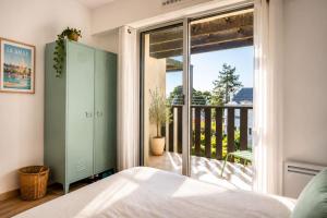 a bedroom with a bed and a window with a balcony at Pool 3 Balconies & Parking in La Baule