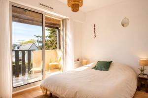 a bedroom with a bed and a large window at Pool 3 Balconies & Parking in La Baule