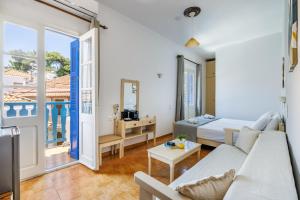 a living room with a couch and a bed at Adonis Rooms in Skopelos Town