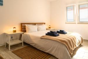 a bedroom with a bed with towels on it at 1bd Apartment close to beach in Lourinhã