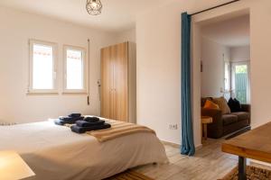 a bedroom with a large bed with blue curtains at 1bd Apartment close to beach in Lourinhã