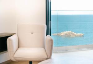 a white chair in a room with a window at Rajna Apartments in Ulcinj